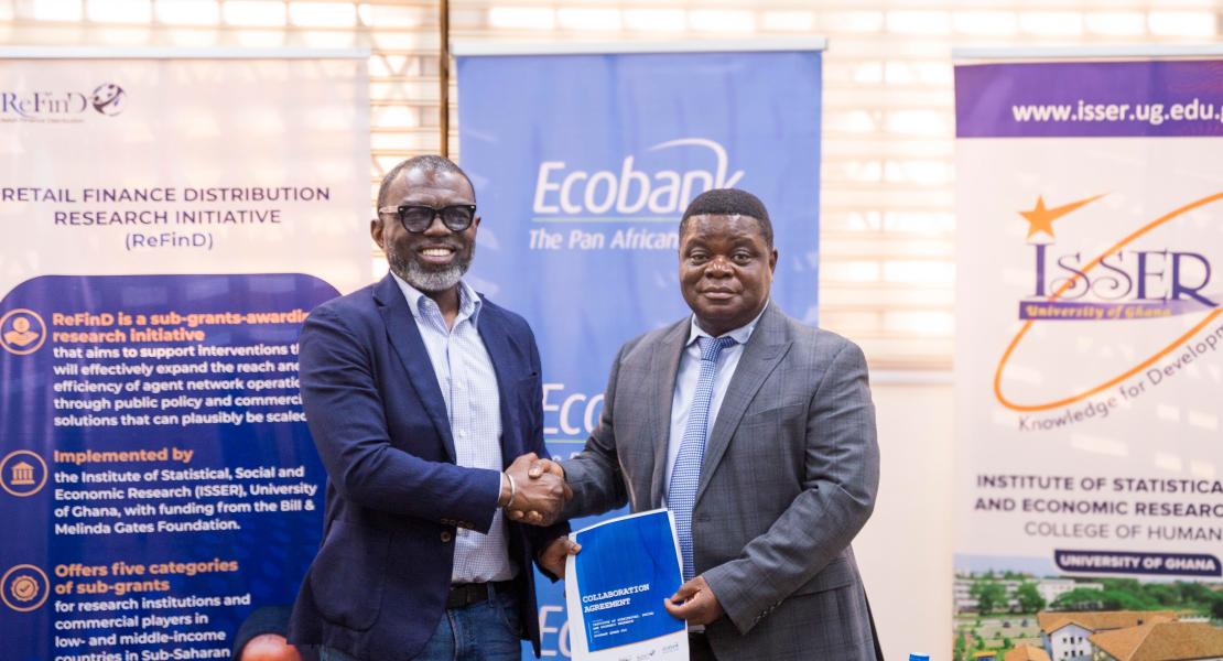Mr. Tara Squire and Prof. Peter Quartey seal the partnership with a handshake after signing the landmark agreement to advance financial inclusion through research and innovation.
